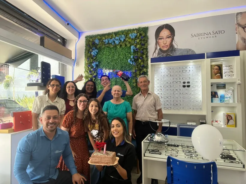 Família de várias gerações reunida em comemoração dentro da Ótica Blulens