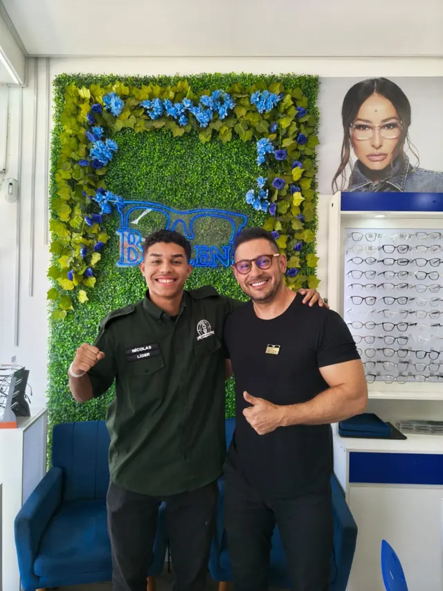 Atendente da Blulens comemorando com um cliente jovem na loja